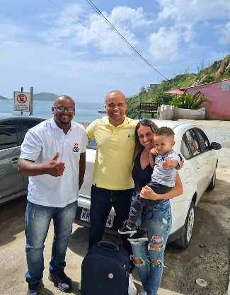 Família ao lado de um veículo em destino litorâneo