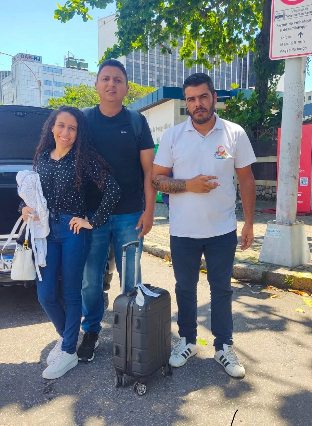 Passageiros com bagagem ao lado do motorista